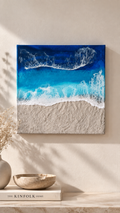 Handgefertigtes quadratisches resin gessobild mit türkisblauem Meer, weissen Wellen und strukturierter Sandfläche. Modernes Meeresbild als Unikat von Solas Artwork.