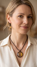 Frau trägt handgefertigtes Schmuckset Solas Aurelia mit runder Halskette und passenden Ohrringen in Gold-, Violett- und Lavendeltönen mit organischer Marmorierung.