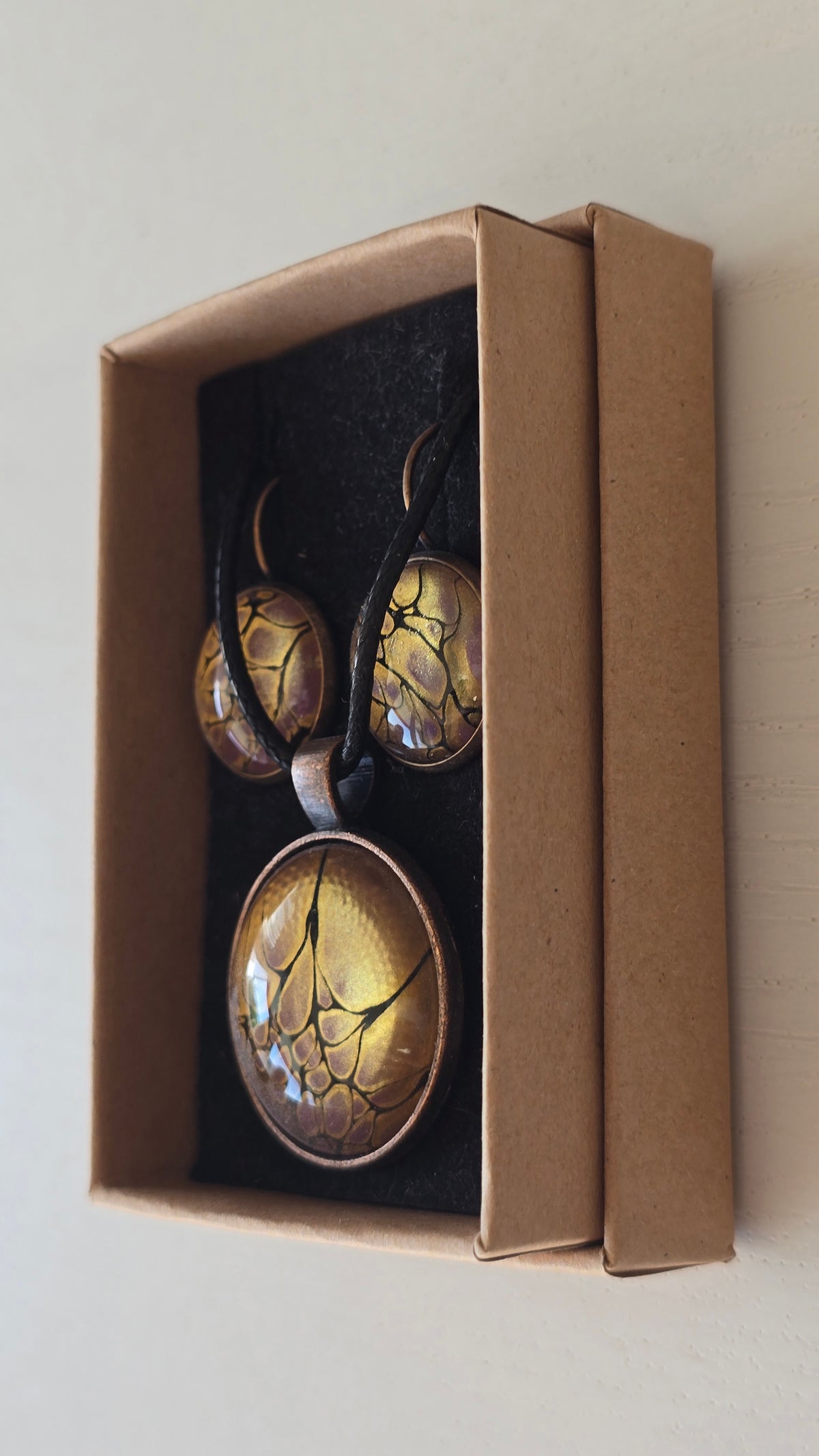 Handgefertigtes Schmuckset Solas Aurelia mit runder Halskette und passenden Ohrringen in Gold-, Violett- und Lavendeltönen mit organischer Marmorierung.
