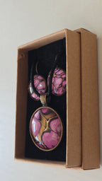 Handgefertigtes Schmuckset Solas Aurora mit rundem Anhänger und passenden Ohrringen in Rosa-, Magenta- und Goldtönen mit fliessendem Marmoreffekt unter Glas.