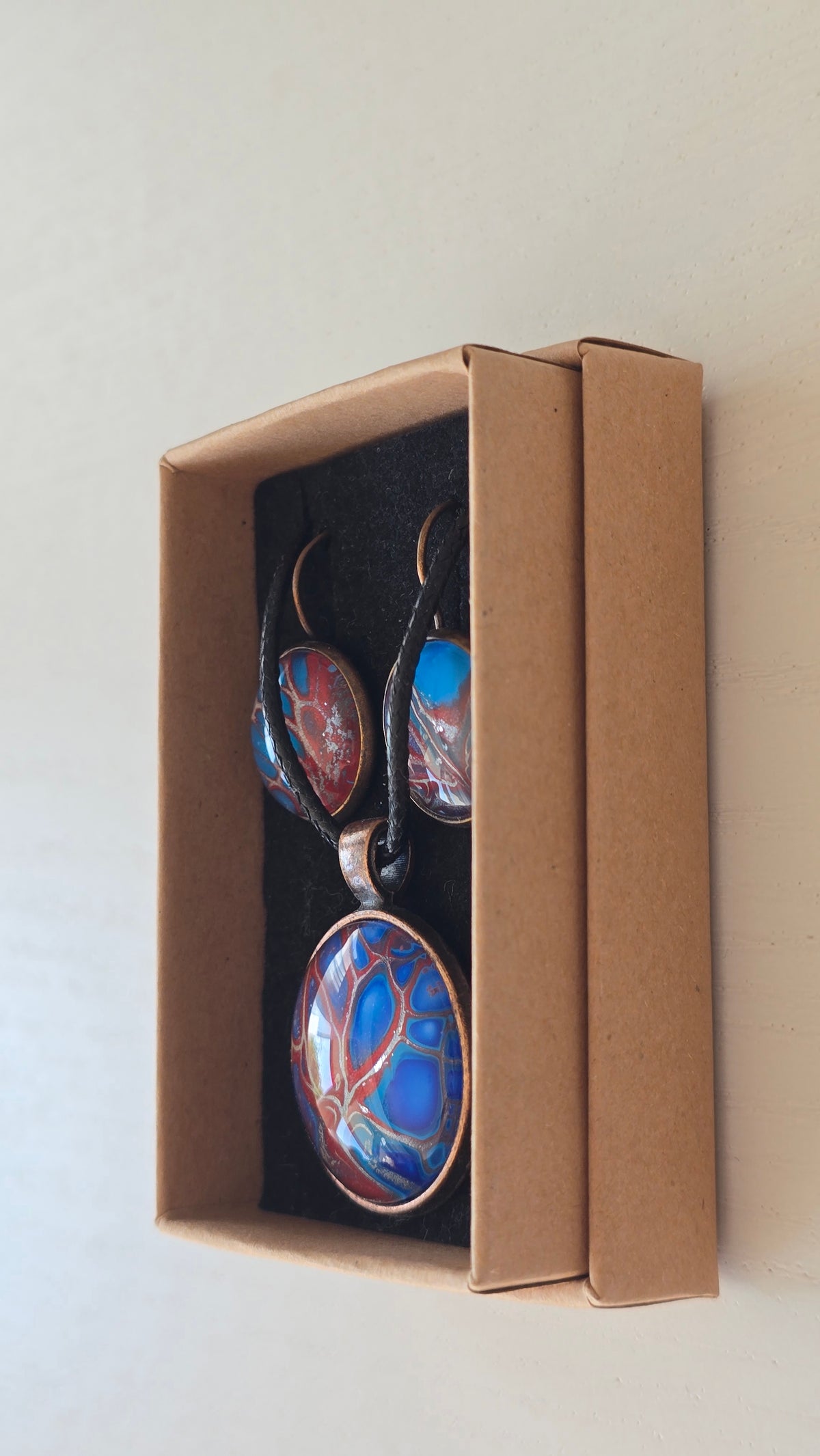 Handgefertigtes Schmuckset Solas Autumn Blush mit Halskette und hängenden Ohrringen in Blau und Rot mit baumähnlichem abstraktem Kunstmotiv.