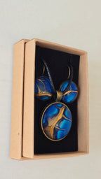 Handgefertigtes Schmuckset Solas Deep Current mit runder Halskette und passenden Ohrringen in tiefen Blau- und Goldtönen mit organischer Marmorierung.