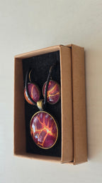 Handgefertigtes Schmuckset Solas Flare mit runder Halskette und passenden Ohrringen in Magenta-, Burgunder-, Orange- und Goldtönen mit leuchtender Marmorierung.