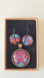 Handgefertigtes Schmuckset Solas Golden Spikes mit runder Halskette und passenden Ohrringen in Violett-, Türkis- und Goldtönen mit markanten goldenen Linien.