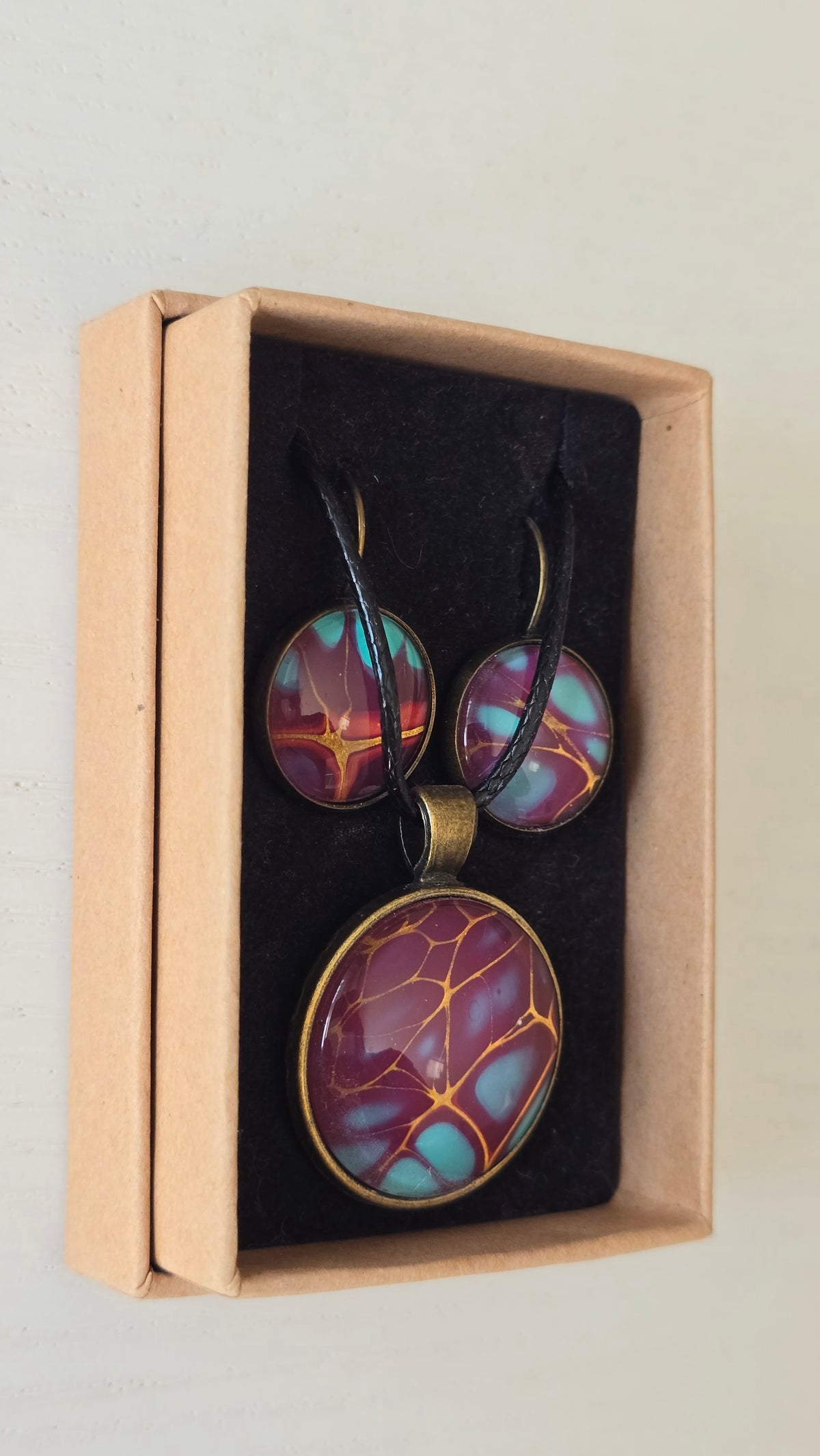 Handgefertigtes Schmuckset Solas Golden Spikes mit runder Halskette und passenden Ohrringen in Violett-, Türkis- und Goldtönen mit markanten goldenen Linien.