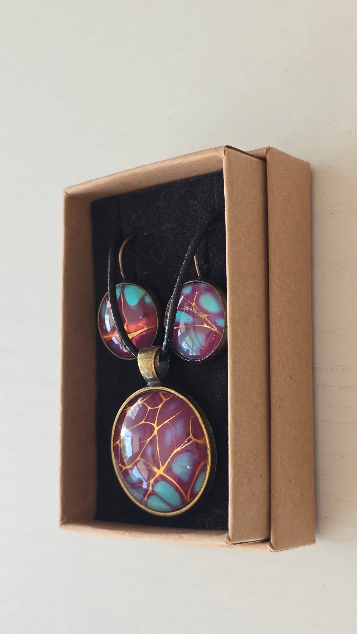 Handgefertigtes Schmuckset Solas Golden Spikes mit runder Halskette und passenden Ohrringen in Violett-, Türkis- und Goldtönen mit markanten goldenen Linien.