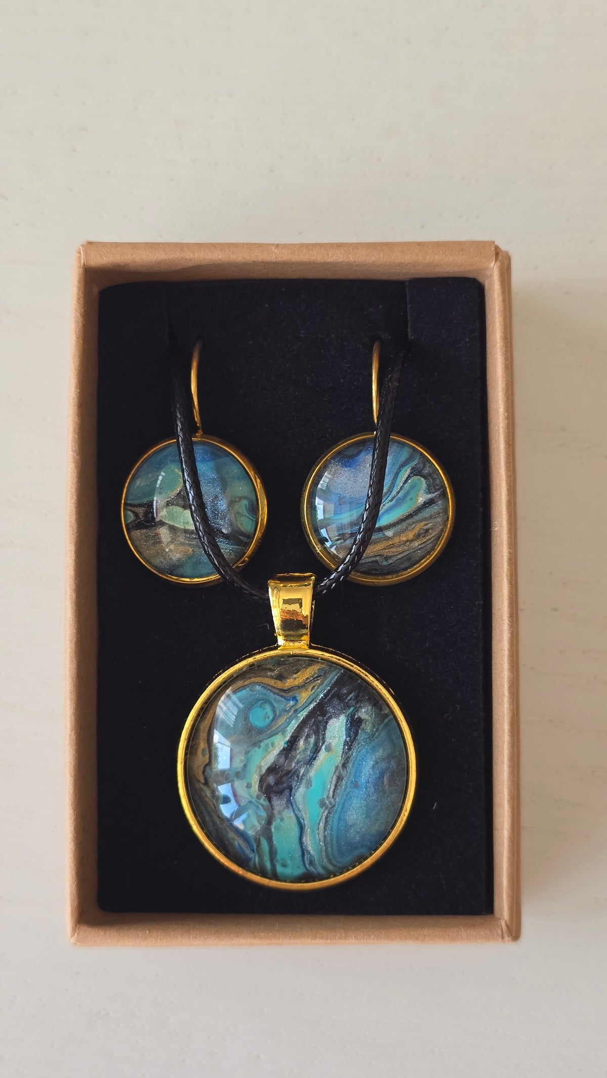 Handgefertigtes Schmuckset Solas Golden Shore mit runder Halskette und passenden Ohrringen in Gold-, Sand-, Türkis- und Blautönen mit maritimer Marmorierung.