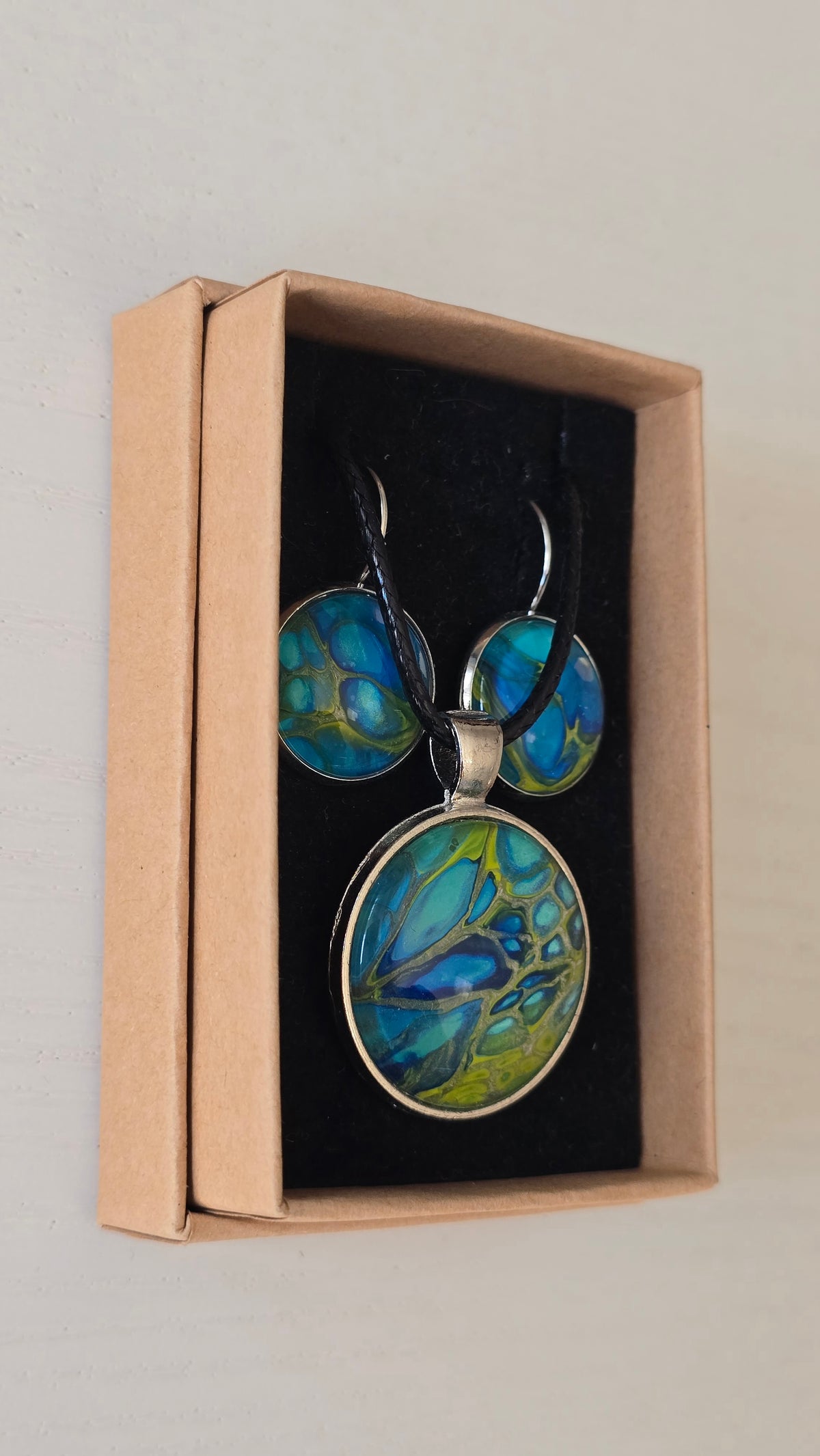 Handgefertigtes Schmuckset Solas Green Horizon mit runder Halskette und passenden Ohrringen in Blau-, Türkis- und Grüntönen mit organischer Marmorierung.