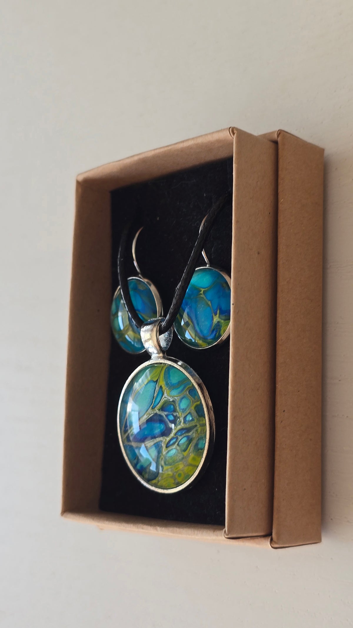 Handgefertigtes Schmuckset Solas Green Horizon mit runder Halskette und passenden Ohrringen in Blau-, Türkis- und Grüntönen mit organischer Marmorierung.