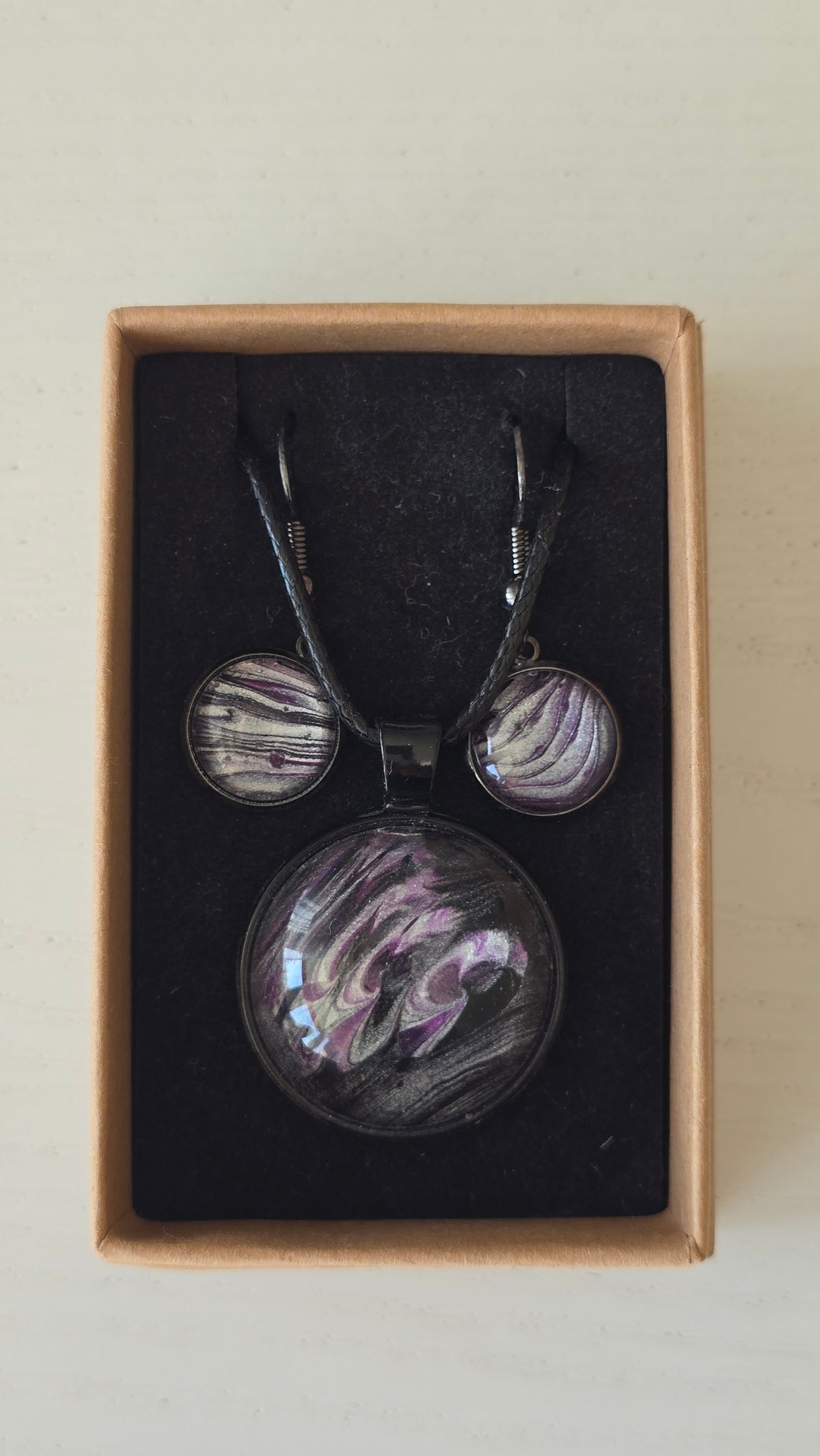 Handgefertigtes Schmuckset Solas Moonshadow mit runder Halskette und passenden Ohrringen in Schwarz-, Silber- und Violetttönen mit organischer Marmorierung.