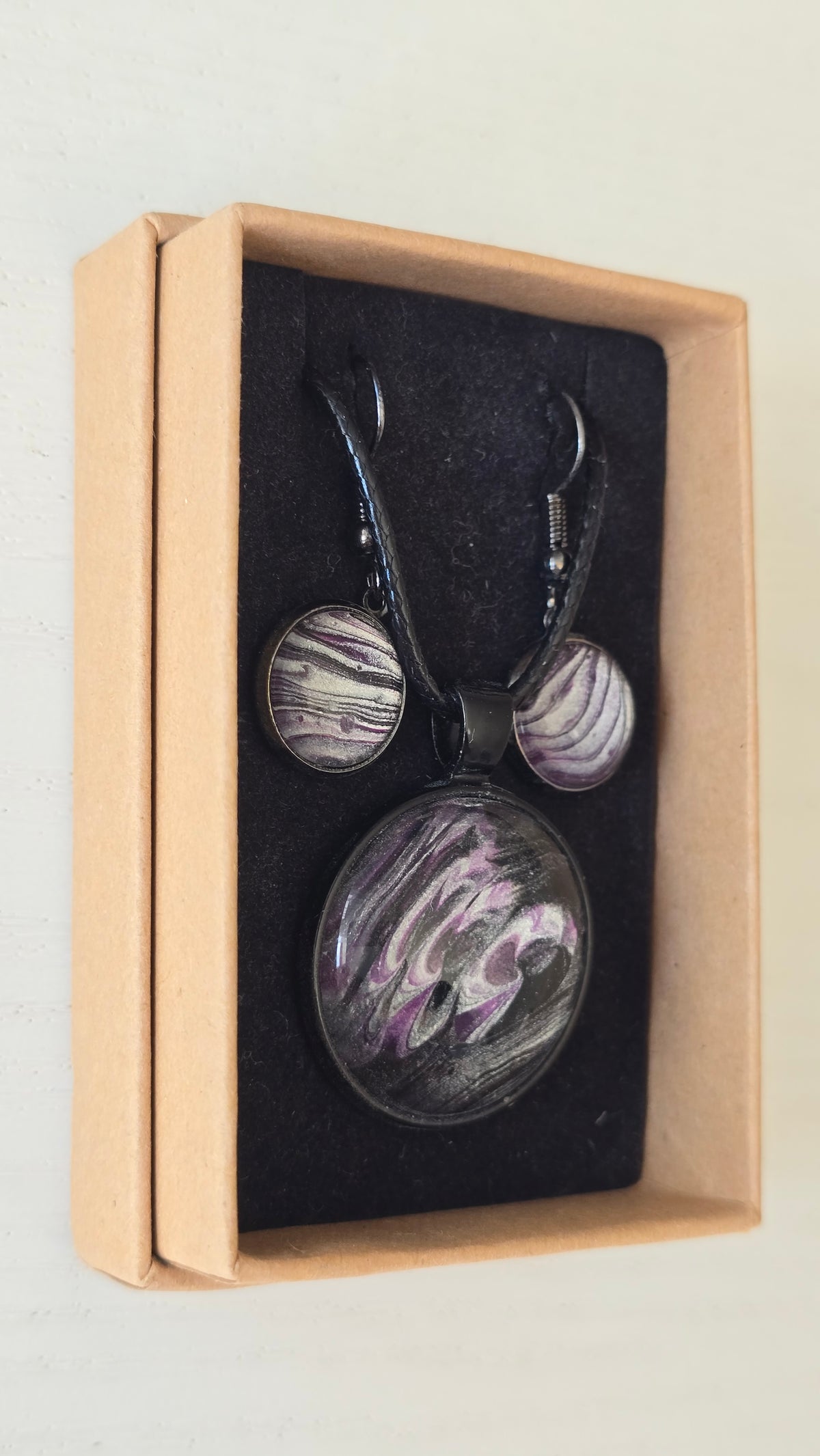 Handgefertigtes Schmuckset Solas Moonshadow mit runder Halskette und passenden Ohrringen in Schwarz-, Silber- und Violetttönen mit organischer Marmorierung.