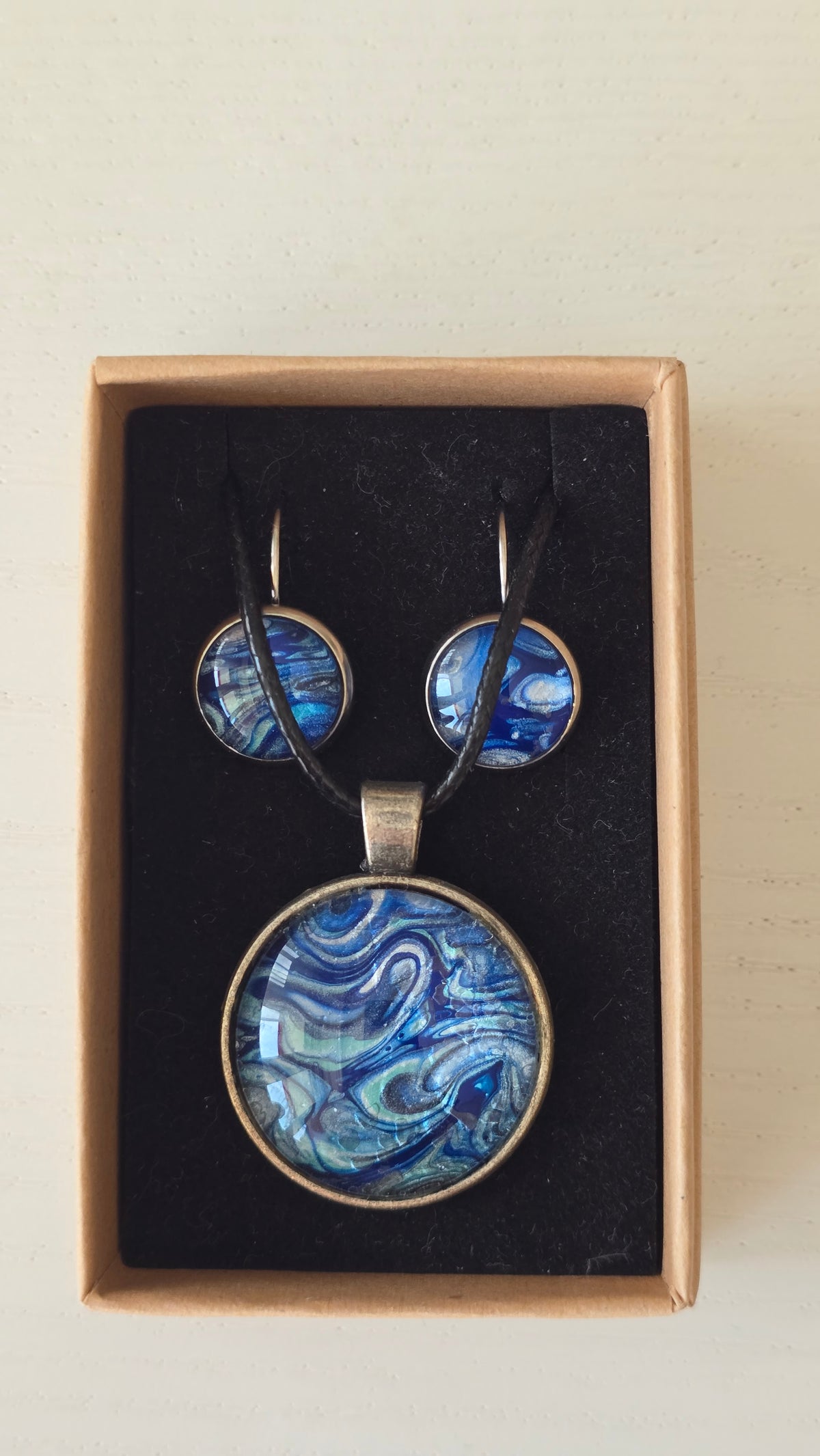 Handgefertigtes Schmuckset Solas Ocean Current mit runder Halskette und passenden Ohrringen in tiefen Blau- und Türkistönen mit fliessendem Marmoreffekt.