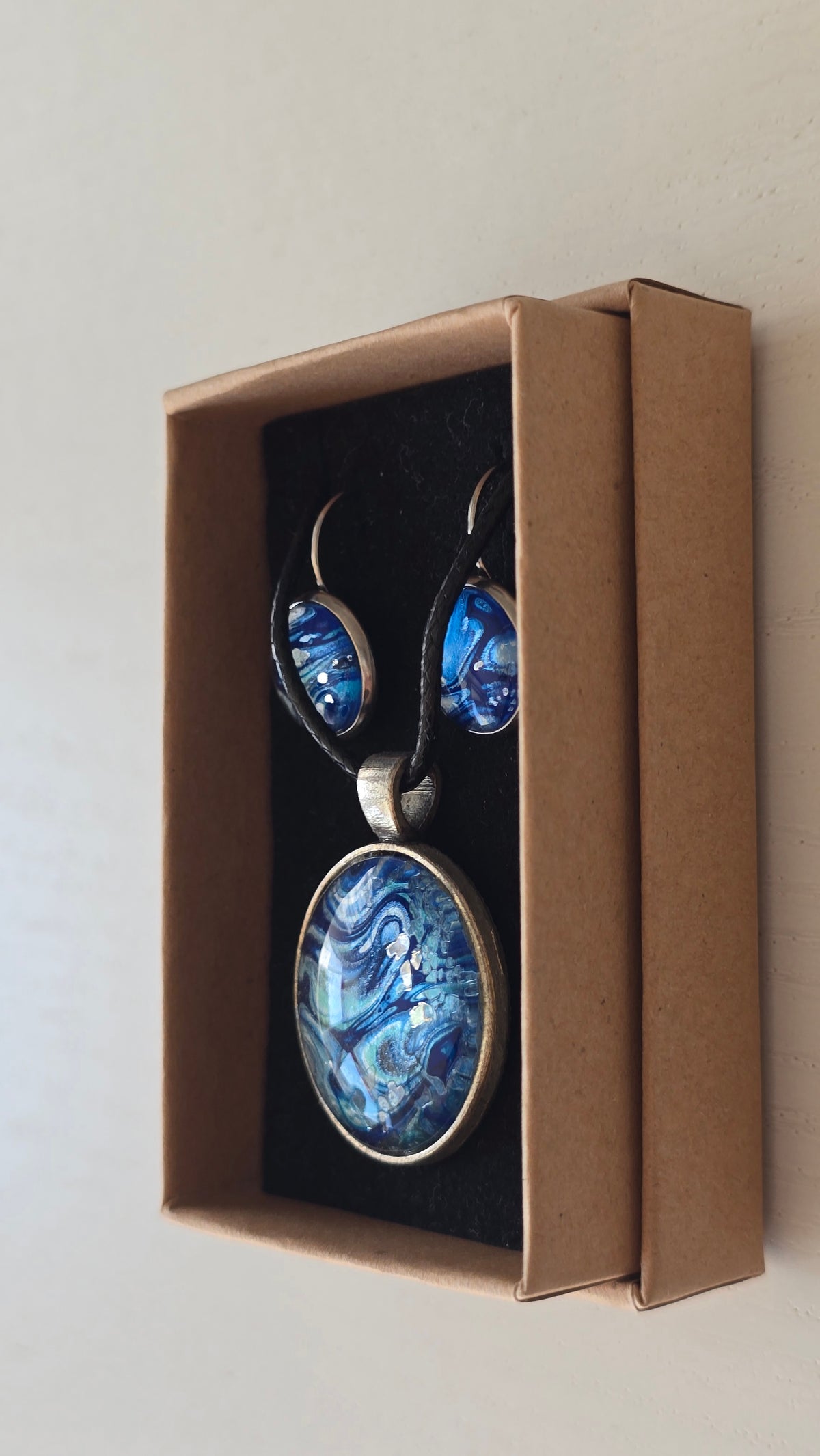 Handgefertigtes Schmuckset Solas Ocean Current mit runder Halskette und passenden Ohrringen in tiefen Blau- und Türkistönen mit fliessendem Marmoreffekt.
