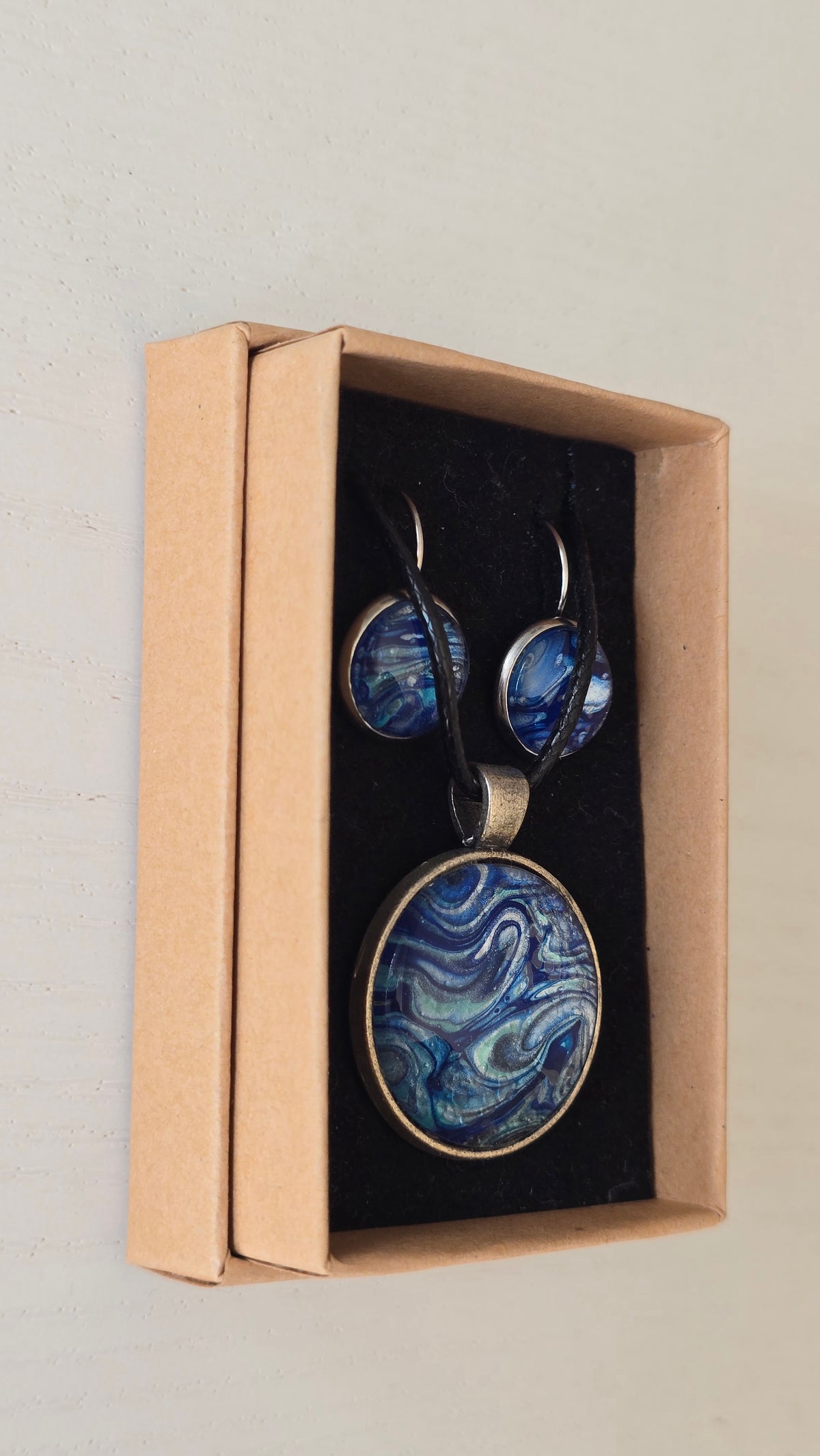 Handgefertigtes Schmuckset Solas Ocean Current mit runder Halskette und passenden Ohrringen in tiefen Blau- und Türkistönen mit fliessendem Marmoreffekt.