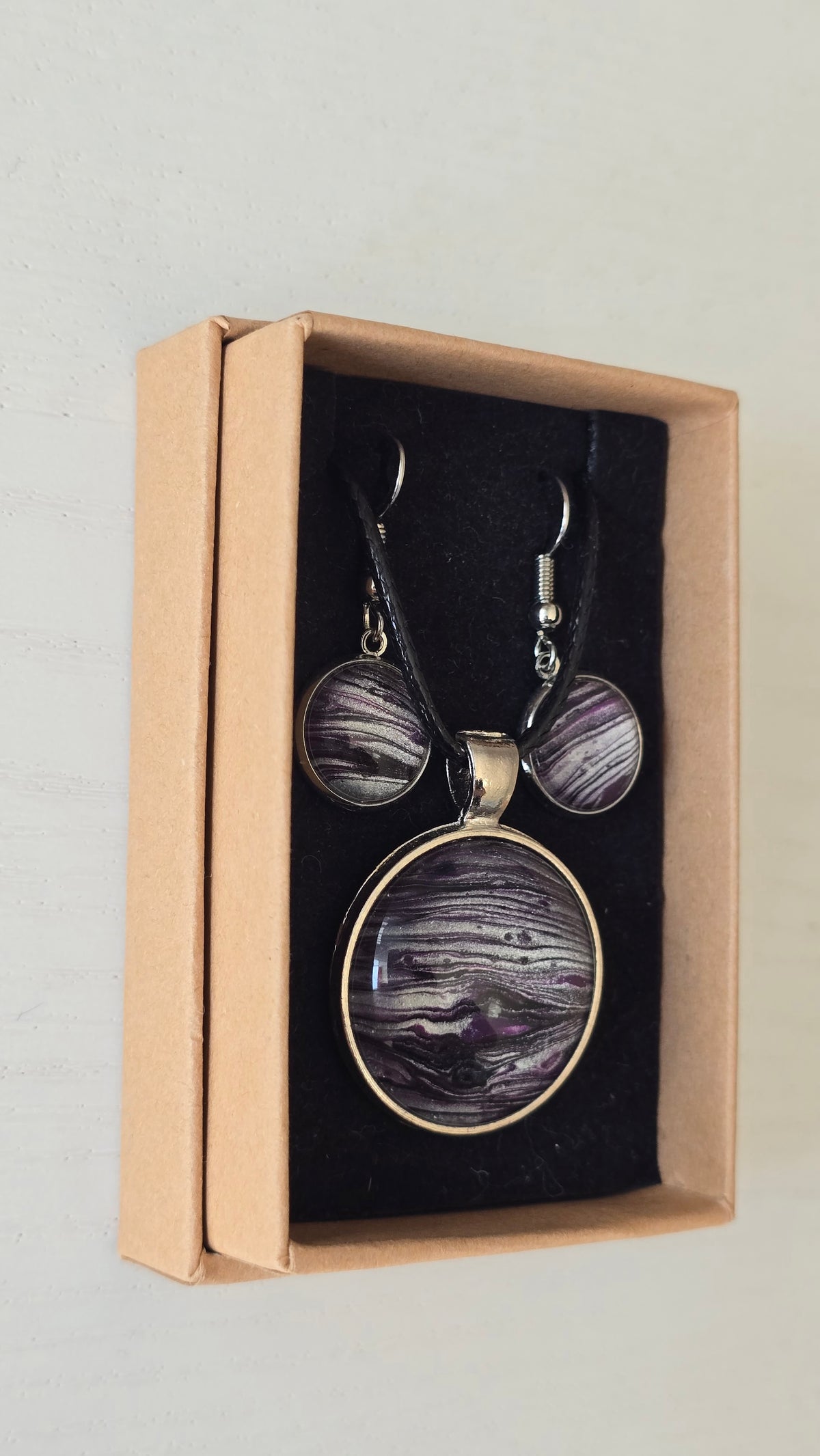 Handgefertigtes Schmuckset Solas Purple Sands mit runder Halskette und passenden Ohrringen in Violett-, Flieder- und Silbertönen mit feiner, sandähnlicher Linienstruktur.