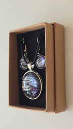 Handgefertigtes Schmuckset Solas Purple Sands mit runder Halskette und passenden Ohrringen in Violett-, Flieder- und Silbertönen mit feiner, sandähnlicher Linienstruktur.