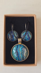Handgefertigtes Schmuckset Solas Tidal Reef mit runder Halskette und passenden Ohrringen in Blau-, Türkis- und Petroltönen mit organischer Marmorierung.