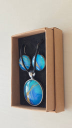 Handgefertigtes Schmuckset Solas Tide mit runder Halskette und passenden Ohrringen in Türkis-, Blau- und goldenen Farbtönen mit fließender Marmorierung.