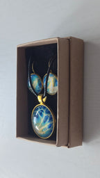 Rundes Cabochon-Schmuckset mit grossem Halskettenanhänger und zwei passenden Ohrringen in Türkis, Blau und Creme mit feinen goldenen Akzenten.