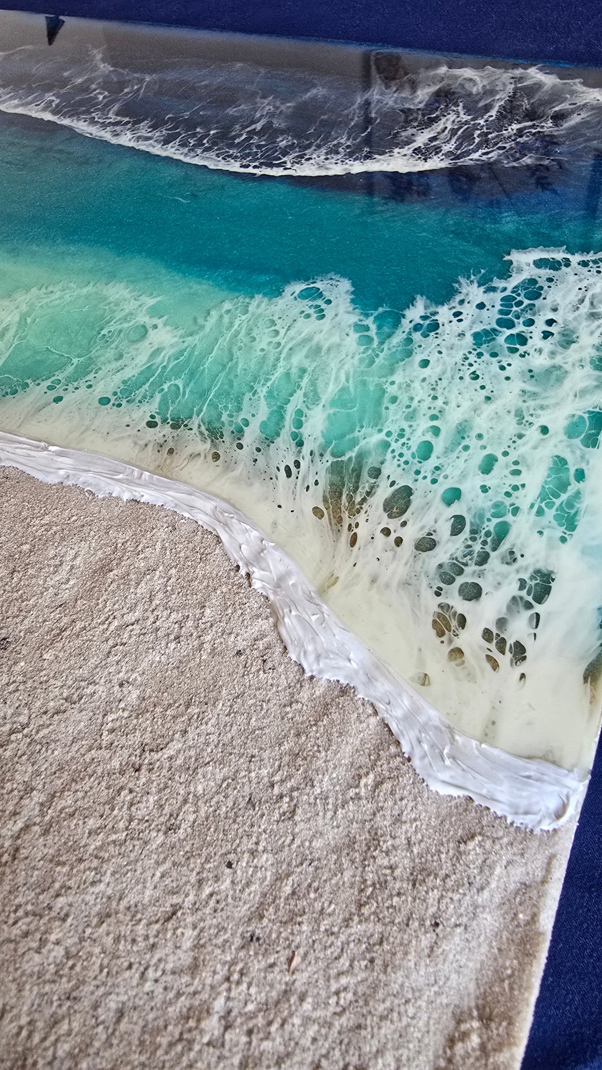 Handgefertigtes quadratisches resin gessobild mit türkisblauem Meer, weissen Wellen und strukturierter Sandfläche. Modernes Meeresbild als Unikat von Solas Artwork.