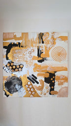 Abstraktes Leinwandbild Aurea 50 × 50 cm mit Gold, Schwarz, Weiss und Perlmutt, geometrischen Formen, Kreisen und plastischen Strukturen.