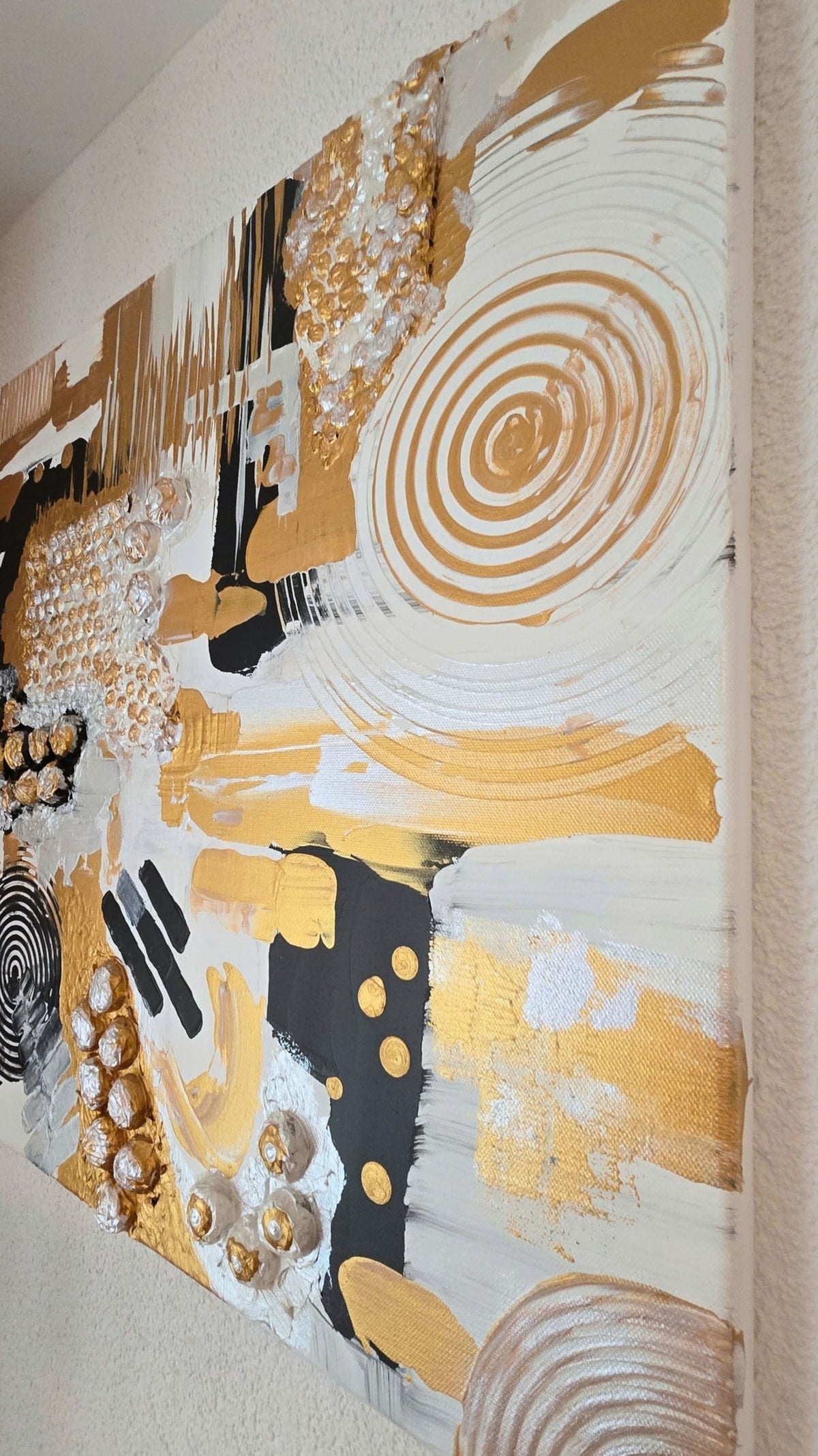 Abstraktes Leinwandbild Aurea 50 × 50 cm mit Gold, Schwarz, Weiss und Perlmutt, geometrischen Formen, Kreisen und plastischen Strukturen.