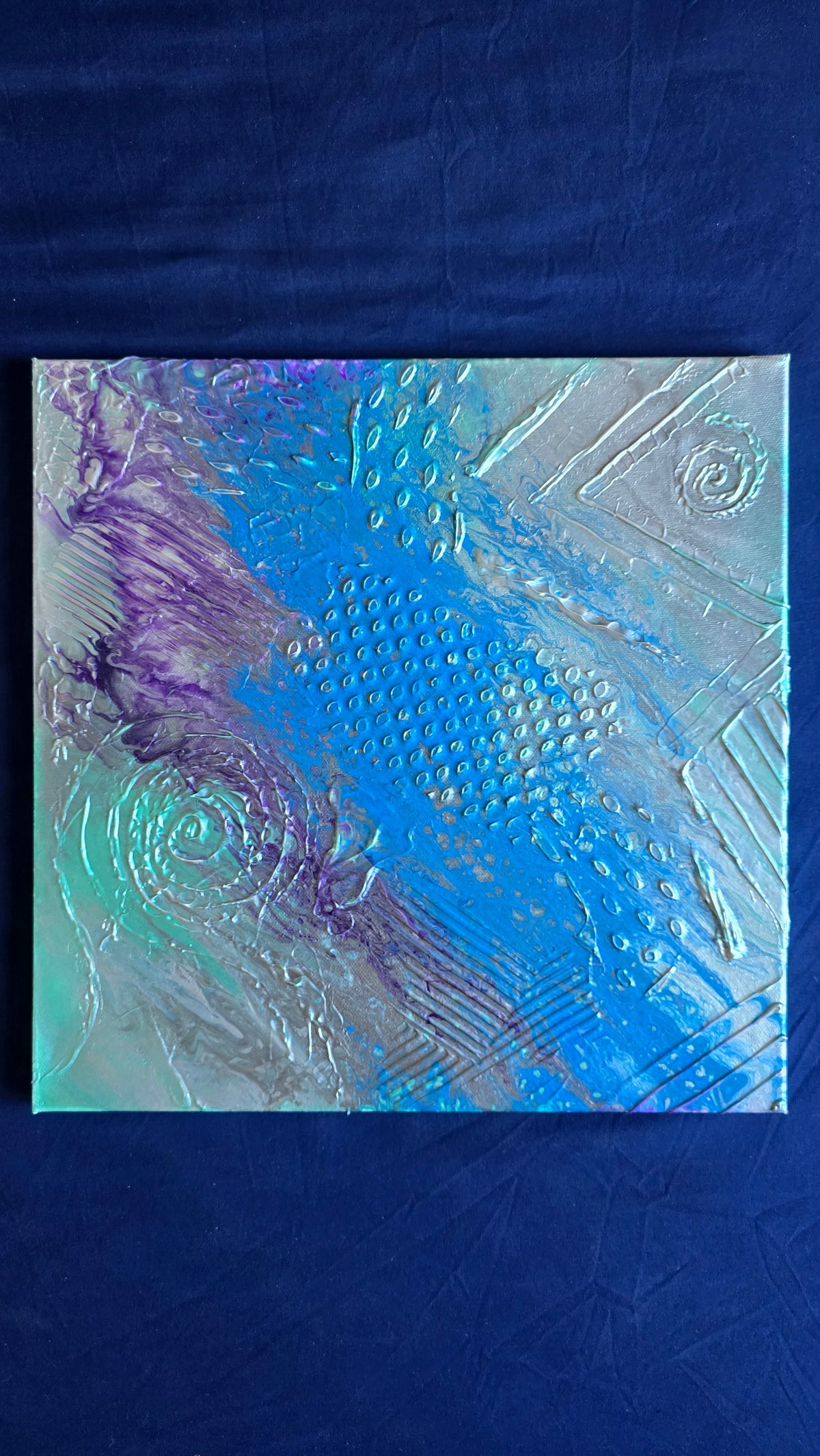 Quadratisches abstraktes Leinwandbild mit strukturierter Oberfläche, kräftigem Blau, Türkis, Violett und Silber sowie Punkten, Linien und Kreisformen.