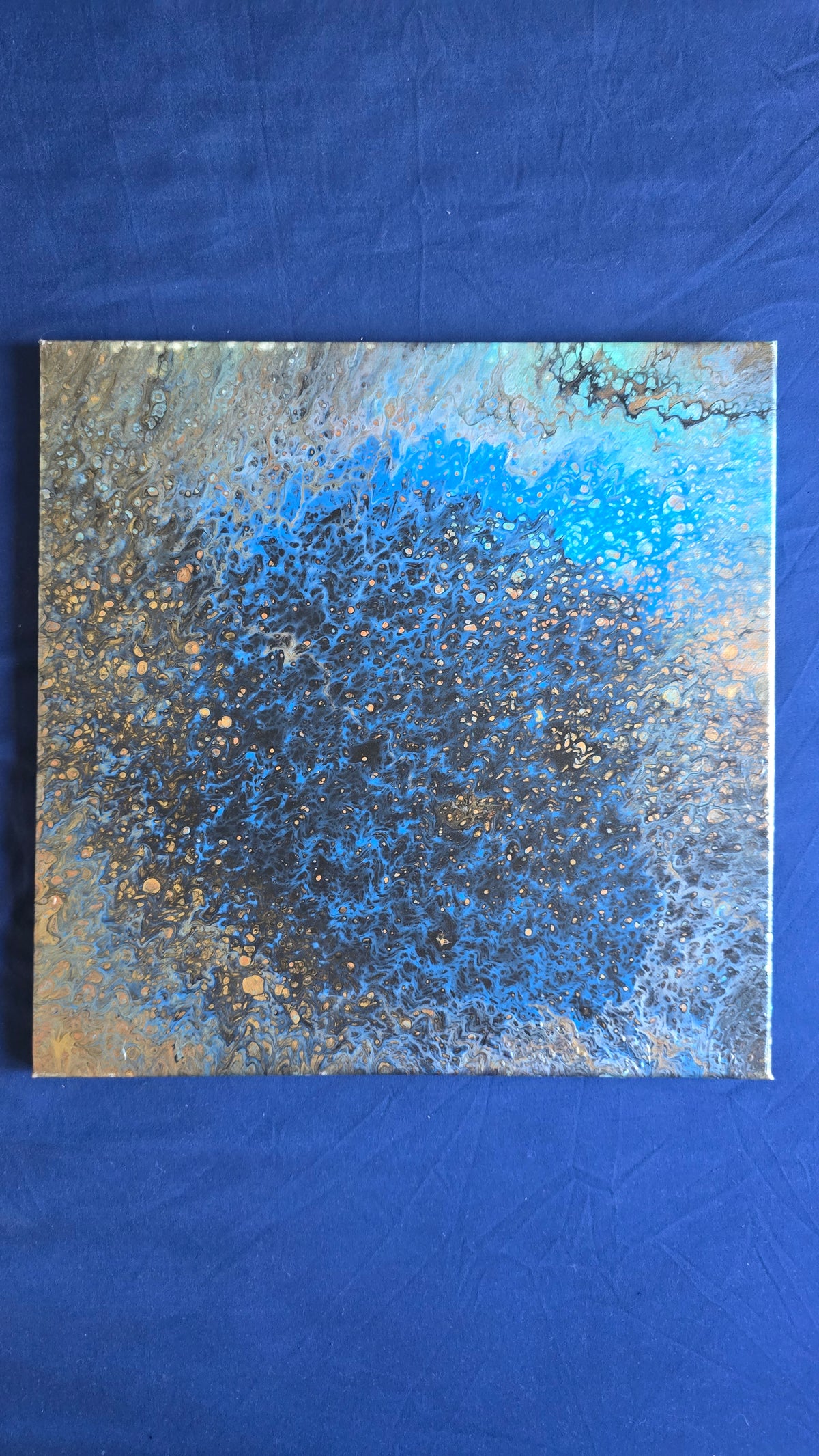 Quadratisches abstraktes Leinwandbild in intensivem Blau und Türkis mit dunklen Zellstrukturen sowie kleinen goldenen und erdigen Akzenten.
