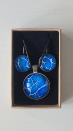Rundes Cabochon-Schmuckset mit Anhänger und Ohrringen an schwarzem Band, in leuchtendem Blau und Cyan mit feinen weissen, verzweigten Linien.