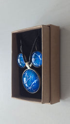 Rundes Cabochon-Schmuckset mit Anhänger und Ohrringen an schwarzem Band, in leuchtendem Blau und Cyan mit feinen weissen, verzweigten Linien.