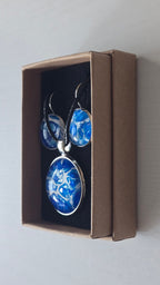 Cabochon Schmuckset Solas Blue Fusion mit runder Kette und zwei Ohrringen in Dunkelblau, Kobaltblau, Türkis und Weiss, silberfarbenen Fassungen und schwarzem Band.