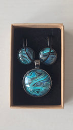 Rundes Cabochon-Schmuckset mit Halskettenanhänger und passenden Ohrringen in Türkis, Blau, Schwarz und Grau mit fliessender marmorierter Maserung.