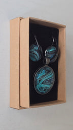 Rundes Cabochon-Schmuckset mit Halskettenanhänger und passenden Ohrringen in Türkis, Blau, Schwarz und Grau mit fliessender marmorierter Maserung.
