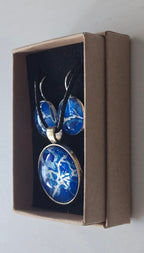 Rundes Cabochon Schmuckset mit grossem Kettenanhänger und zwei passenden Ohrringen in kräftigem Blau und Türkis mit weissen, verzweigten Strukturen, silberfarbenen Fassungen und schwarzem Band.