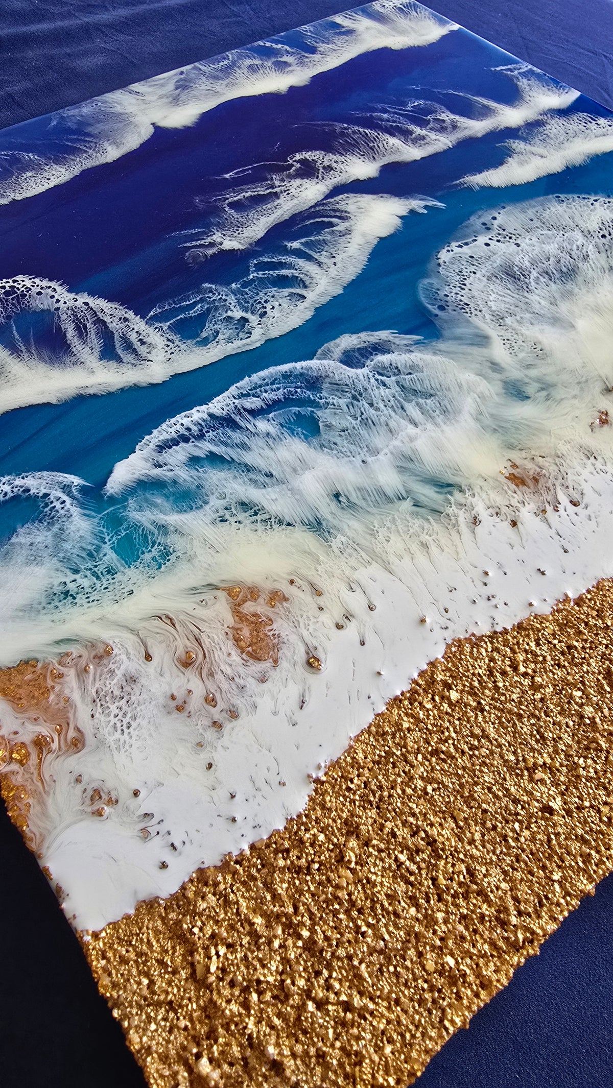 Resin Wandbild Solas Breaking Blue mit tiefblauem und türkisem Meer, mehreren weissen Wellen und strukturiertem goldfarbenem Küstenbereich.