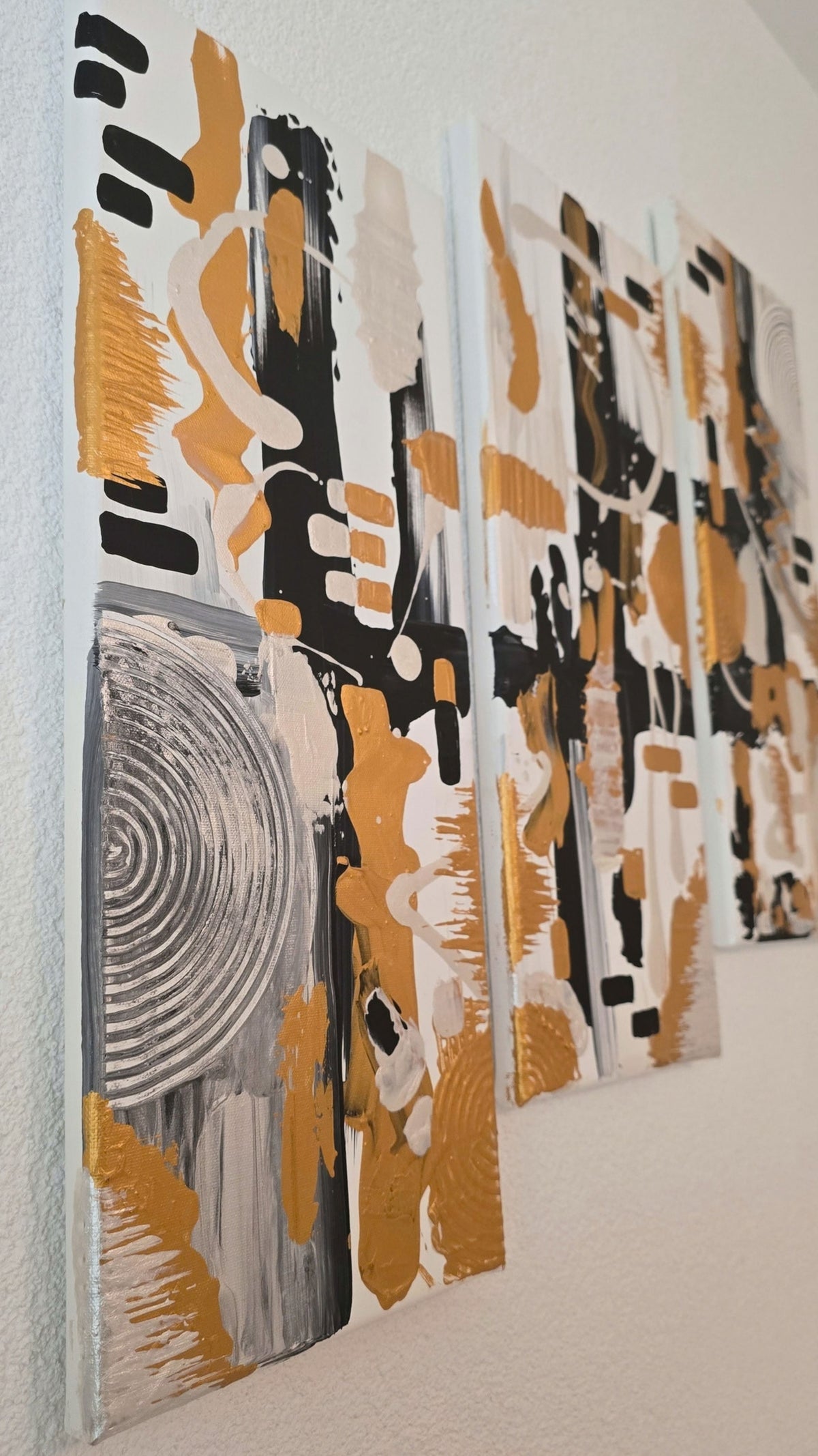 Dreiteiliges abstraktes Struktur Leinwandbild Cadence in Gold, Schwarz, Weiss und Silber mit Kreisen, Linien und plastischen Elementen.