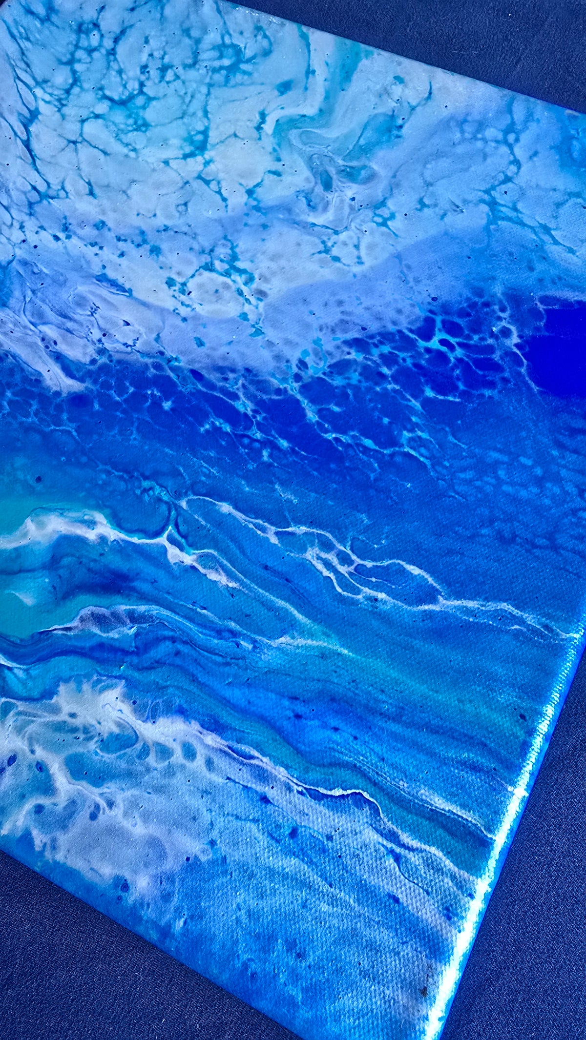 Quadratisches abstraktes Leinwandbild in Weiss, Hellblau, Türkis und kräftigem Blau mit fliessenden, wolkenartigen Strukturen.