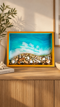 Handgefertigtes Resin-Kunstwerk «Solas Coastal Treasures» mit türkisfarbenem Meer, schäumenden Wellen, echten Muscheln, Steinen und Treibholz in einem goldenen Rahmen, 40 × 30 cm.