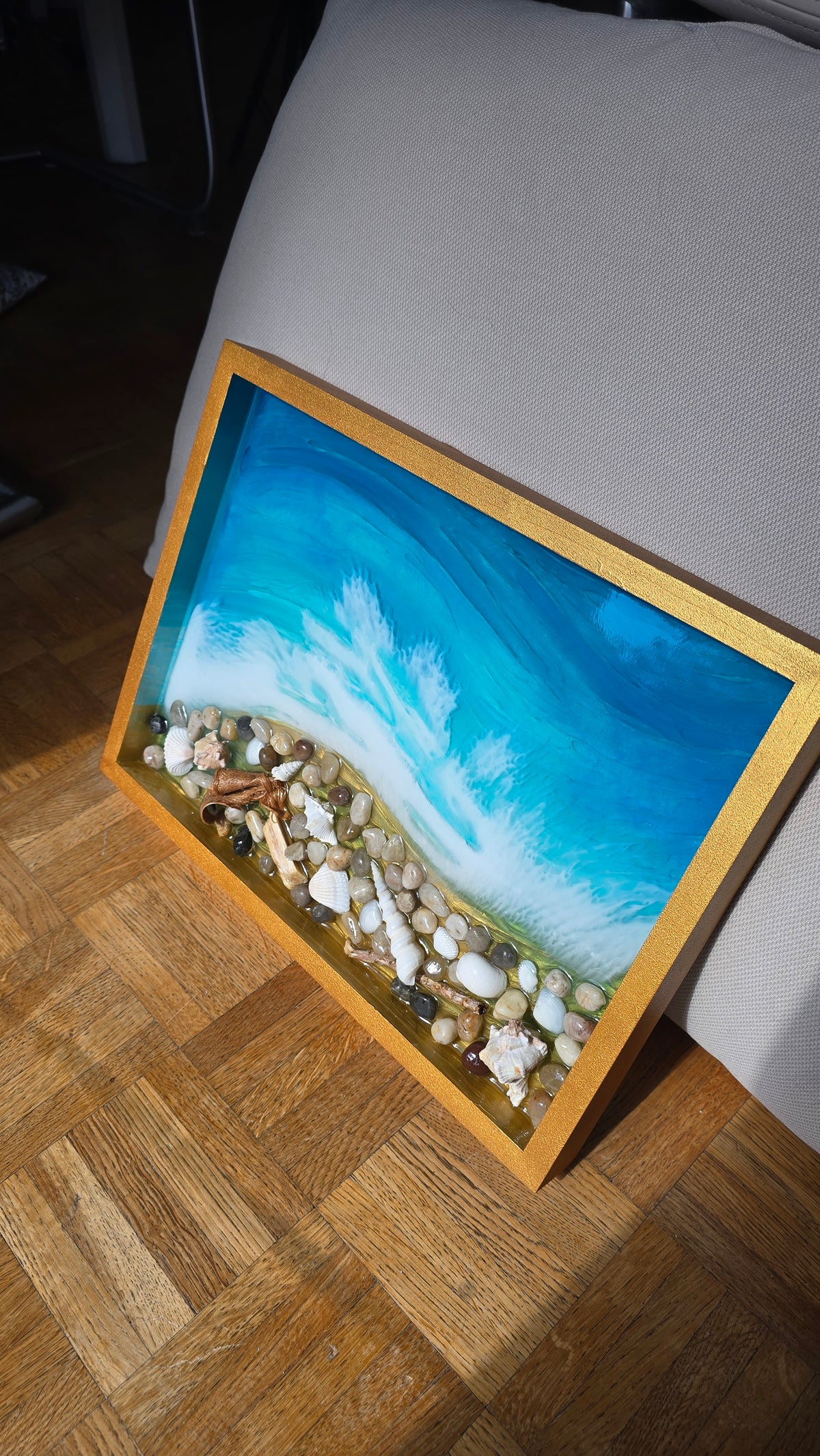 Handgefertigtes Resin-Kunstwerk «Solas Coastal Treasures» mit türkisfarbenem Meer, schäumenden Wellen, echten Muscheln, Steinen und Treibholz in einem goldenen Rahmen, 40 × 30 cm.