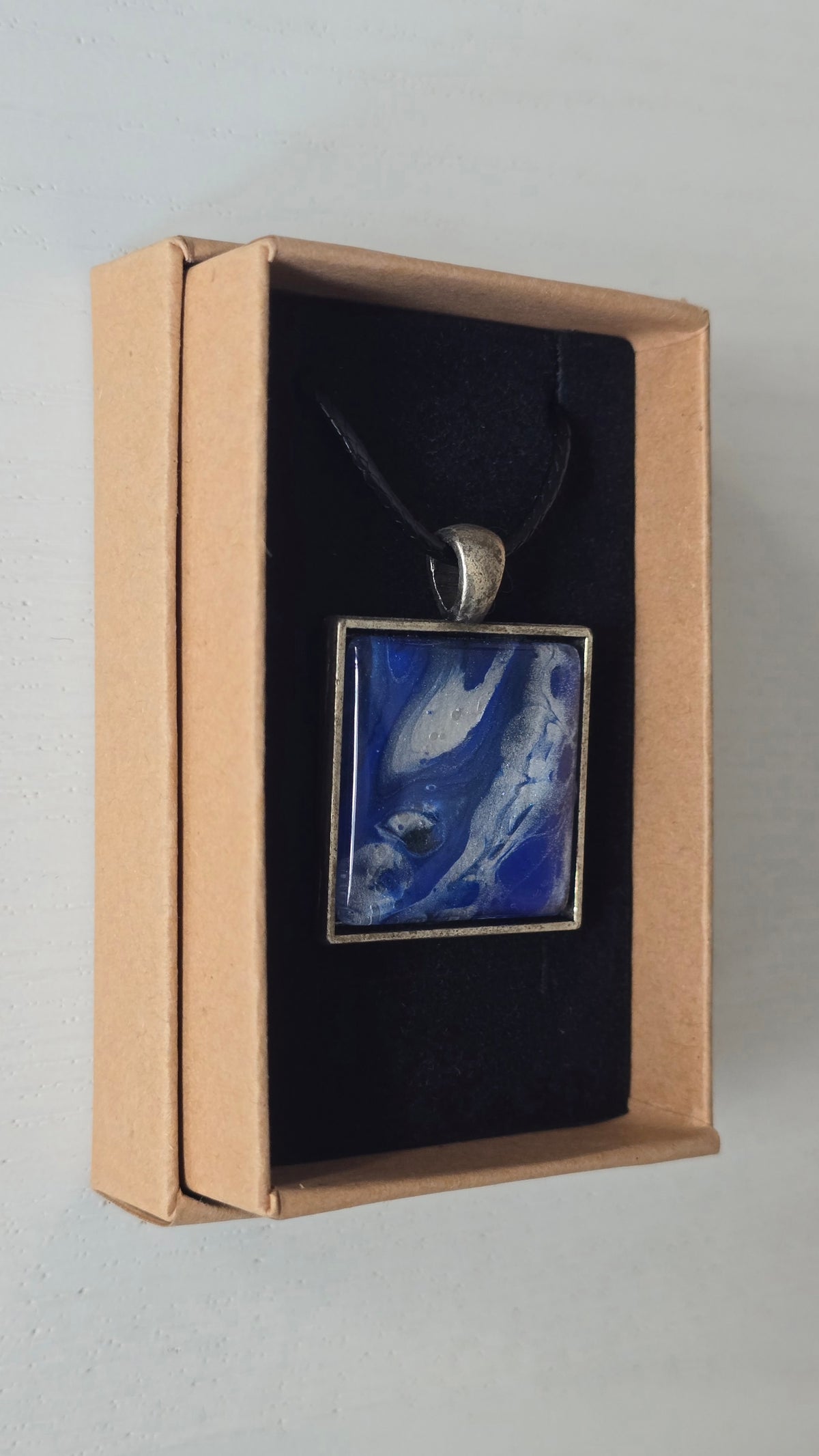 Quadratische Cabochon-Kette mit fliessendem Muster in intensivem Kobaltblau und metallisch schimmerndem Silber.