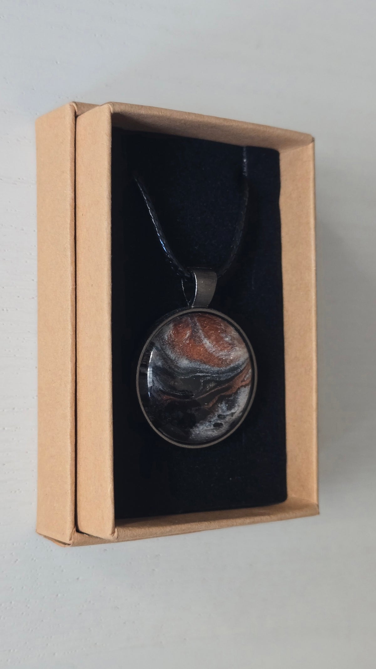 Runde Cabochon-Kette mit abstrakten Strukturen in schimmerndem Kupfer, Schwarz, Anthrazit und Silber in dunkler Metallfassung.