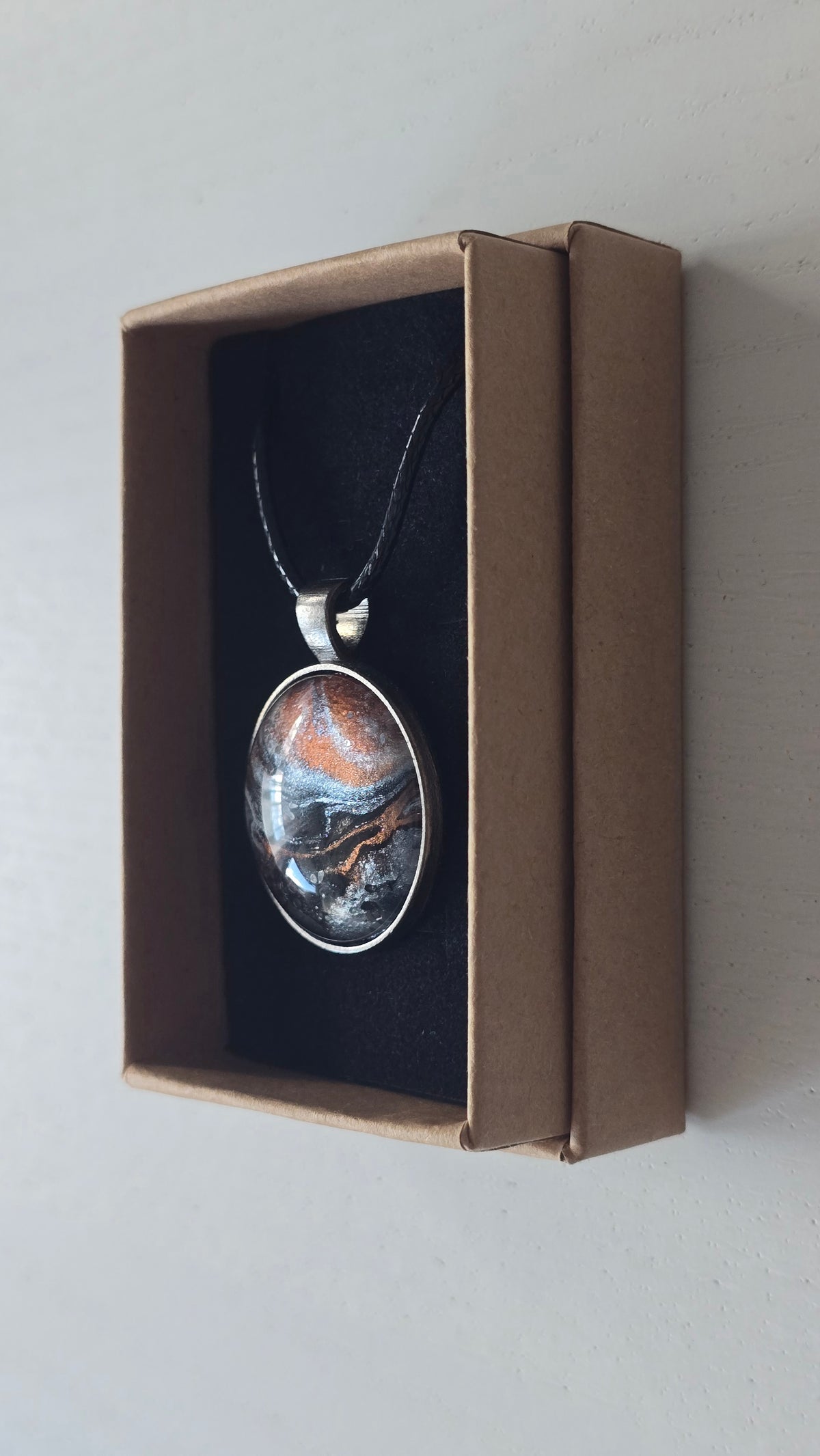 Runde Cabochon-Kette mit abstrakten Strukturen in schimmerndem Kupfer, Schwarz, Anthrazit und Silber in dunkler Metallfassung.