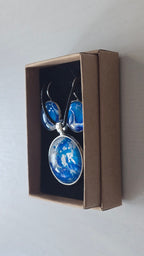 Cabochon Schmuckset Solas Crystal Wave mit runder Kette und passenden Ohrringen in leuchtendem Blau, Türkis und Weiss mit silberfarbenen Fassungen.
