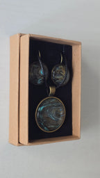 Rundes Cabochon Schmuckset mit Kette und zwei Ohrringen, abstraktes Muster in Schwarz, Türkis, Blaugrün und Gold mit fliessenden Strukturen.