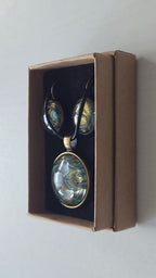 Rundes Cabochon Schmuckset mit Kette und zwei Ohrringen, abstraktes Muster in Schwarz, Türkis, Blaugrün und Gold mit fliessenden Strukturen.