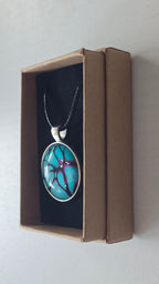 Runde Cabochon-Kette in leuchtendem Türkis mit verzweigten Strukturen in Violett, Pink und Schwarz.
