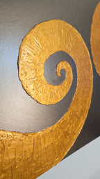 Quadratisches Leinwandbild mit warmgrauem Hintergrund und zwei grossen, plastisch strukturierten goldenen Spiralen.