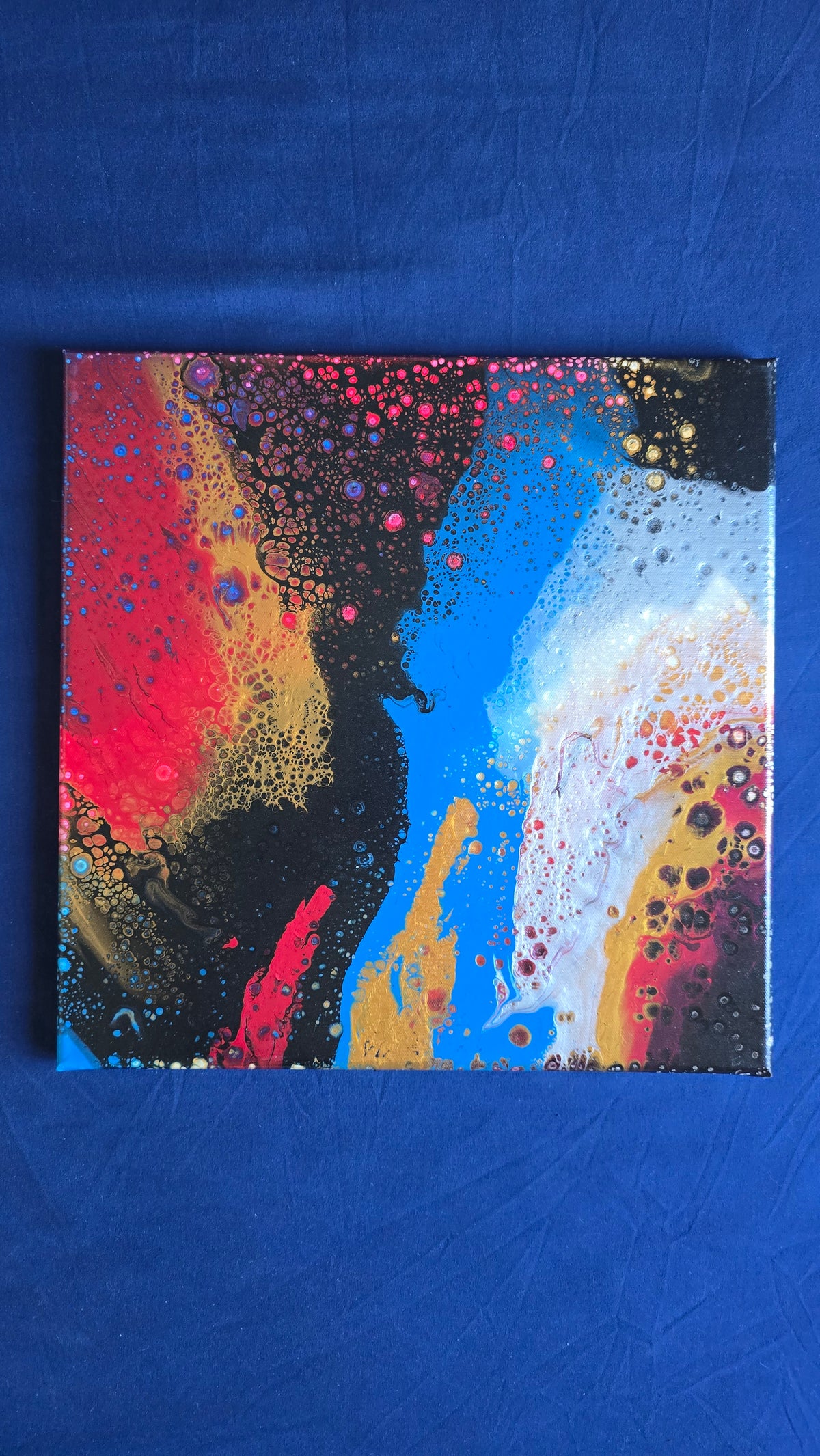 Drei abstrakte Leinwandbilder in unterschiedlichen Grössen mit fliessenden Farbflächen und feinen Zellstrukturen in Rot, Blau, Gold, Schwarz und Weiss.