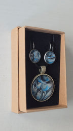Rundes Cabochon-Schmuckset mit Anhänger und Ohrringen an schwarzem Band, mit marmoriertem Muster in Blau, Cyan, Silber-/Perlgrau, Anthrazit und Schwarz.