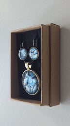 Rundes Cabochon-Schmuckset mit Anhänger und Ohrringen an schwarzem Band, mit marmoriertem Muster in Blau, Cyan, Silber-/Perlgrau, Anthrazit und Schwarz.